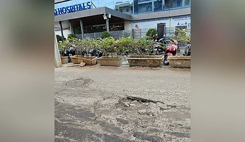 Pothole-ridden road near a multi-specialty hospital in Pragathi Nagar