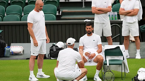 Novak Djokovic of Serbia speaks to a coach during a practice session at the All England Lawn Tennis and Croquet Club, ahead of the Wimbledon Championships in London, Thursday, June 26, 2025.