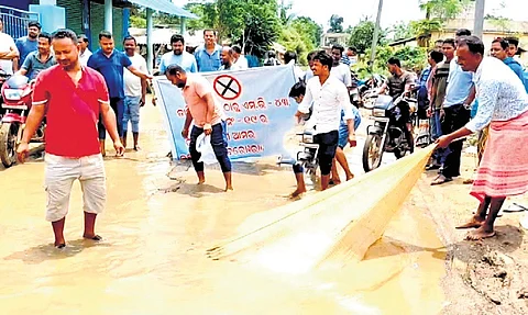 Villagers in the waterlogged road during protest on Saturday
