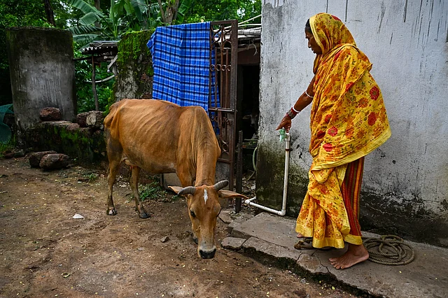 \Kanakalata Das stands holding the tap that has been lying defunct for the past several months in Pakhara Village under Dharmasala block in Jajpur district.