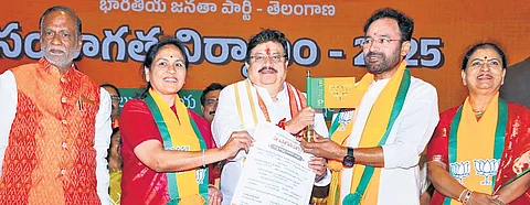 Outgoing Telangana BJP president G Kishan Reddy passes the baton to his successor N Ramchander Rao on Tuesday.