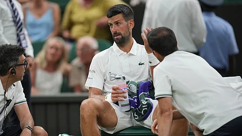 Novak Djokovic of Serbia receives treatment during a medical timeout as he plays Alexandre Muller of France during their first round men's singles match at the Wimbledon Tennis Championships in London, Tuesday, July 1, 2025.