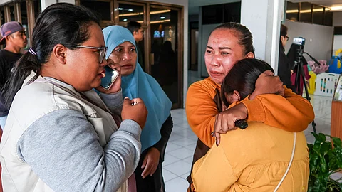 Family members and relatives wait for updates on the search operation of at least 61 people who were missing after a ferry sank off the popular Indonesian resort island of Bali, at Ketapang Port in Banyuwangi, East Java on July 3.