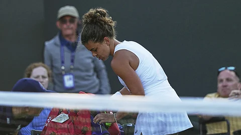 Jasmine Paolini of Italy packs up to leave the court after losing to Russia's Kamilla Rakhimova during their second round women's singles match at the Wimbledon Tennis Championships in London, Wednesday, July 2, 2025