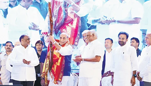 Defence Minister Rajnath Singh takes aim with a bow and an arrow presented to him during the 128th birth anniversary celebrations of freedom fighter Alluri Sitarama Raju at Shilpakala Vedika in Hyderabad on Friday