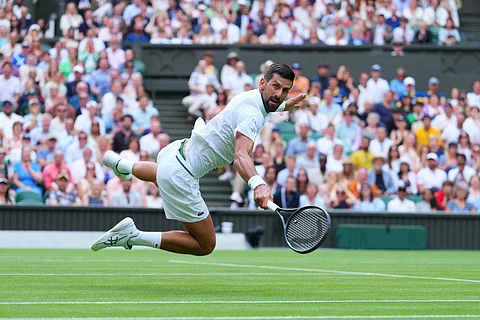Novak Djokovic of Serbia dives to return to Miomir Kecmanovic of Serbia during a third round men's singles match at the Wimbledon Tennis Championships in London, Saturday, July 5, 2025.