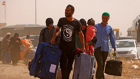 Afghan refugees arrive from Iran at Islam Qala border between Afghanistan and Iran, on July 5, 2025. At Herat province's Islam Qala crossing, the checkpoint is usually busy handling everything from smuggling to deportation as young men seek work in Iran. But since Tehran ordered Afghans without the right to remain to leave by July 6, the number of returnees -- especially families -- has surged.