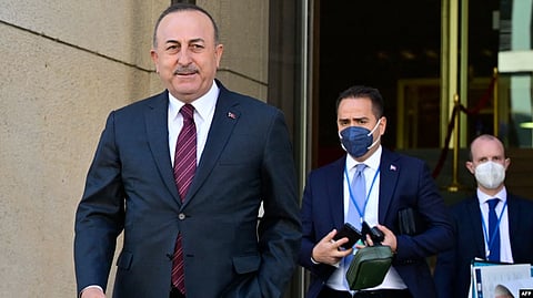 Turkish Foreign Minister Mevlut Cavusoglu, left, walks out of the building during a break of an informal meeting of NATO Foreign Ministers on the conflict in Ukraine on May 15, 2022, in Berlin.