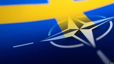 Swedish and NATO flags are seen printed on paper this illustration taken Apr. 13, 2022. (Reuters via VOA)