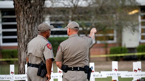 Texas Department of Public Safety officers stand in front of a memorial outside Robb Elementary school, after a gunman killed nineteen children and two teachers, in Uvalde, Texas, May 26, 2022. (VOA)