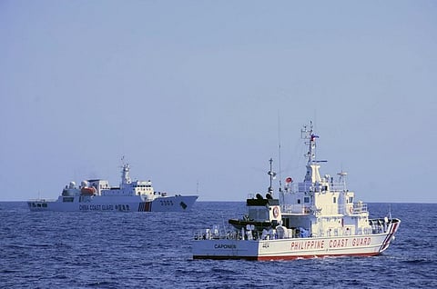 A Chinese coast guard ship (L) shadowing a Philippine coast guard vessel (R) while conducting a maritime patrol in Scarborough Shoal in the South China Sea, in photo taken on March 2, 2022 and released by Philippine Coast Guard on March 27.