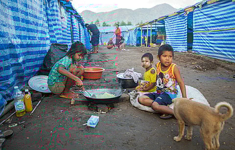 Myanmar refugee children, who fled a surge in violence as the military cracked down on rebel groups, cook a meal at a camp in Nawphewlawl near the Myanmar-Thailand border in Kayin state, Feb. 14, 2022.
