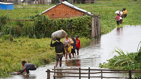 Residents wade through flood water around their homes after heavy rain in Antananarivo, Madagascar, Jan. 19, 2022.