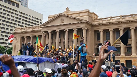 Protesters, many carrying Sri Lankan flags, gather outside the president's office in Colombo, Sri Lanka, on July 9, 2022.