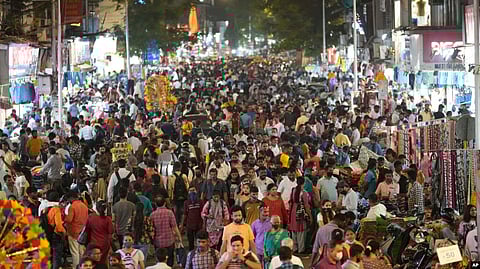People crowd a market area outside a train station in Mumbai, India, March 12, 2022.