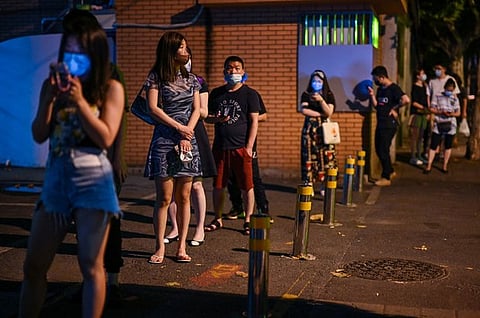 People wait in a line to be tested for the Covid-19 coronavirus in the Jing'an district of Shanghai, July 11, 2022.