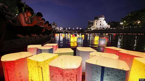 People release paper lanterns on the Motoyasu River facing the gutted Atomic Bomb Dome in remembrance of atomic bomb victims on the 77th anniversary of the bombing, in Hiroshima, Japan, Aug. 6, 2022.