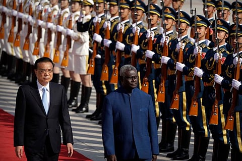 Chinese Premier Li Keqiang, left, and Solomon Islands Prime Minister Manasseh Sogavare review an honor guard during a welcome ceremony at the Great Hall of the People in Beijing, Wednesday, Oct. 9, 2019.