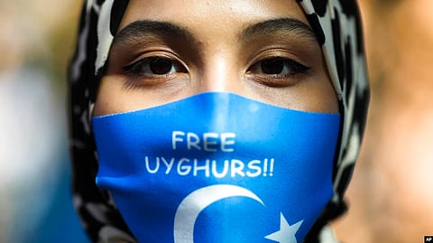 A woman wears a mask reading "Free Uyghurs" at a protest during the visit of Chinese Foreign Minister Wang Yi in Berlin, Sept. 1, 2020. In the U.S., the Biden administration called on China on Sept. 1, 2022, to stop “atrocities” against Uyghurs and other ethnic minorities.