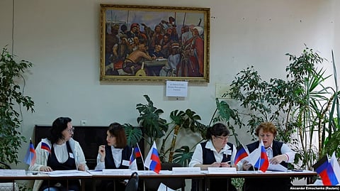 Russia-Ukraine War: Members of an electoral commission wait for voters at a polling station in the Donetsk region during a referendum on the territory joining the Russian federation, which has been dismissed by Ukraine, Western governments, and the United Nations because the vote is illegal under international law.