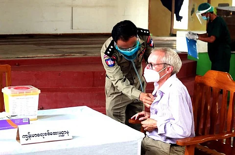 This handout photo from the state-run Myanmar News Agency (MNA) taken on July 28, 2021, and received on July 29 shows Sean Turnell, a detained Australian adviser to Myanmar's deposed leader Aung San Suu Kyi, getting vaccinated against the Covid-19 coronavirus in Insein prison in Yangon.