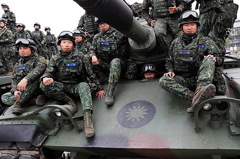 Soldiers sit on an M60A3 tank for a group photograph after an anti-invasion drill in Taichung, Taiwan, Jan. 17, 2019.