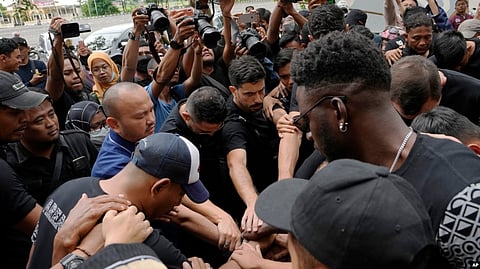 Players and officials of the soccer club Arema FC pray outside the Kanjuruhan Stadium where many fans lost their lives in a stampede Saturday night in Malang, Indonesia, Oct. 3, 2022.