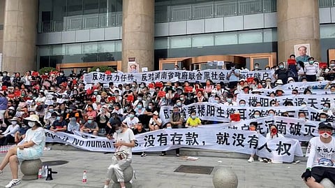 Demonstrators hold banners during a protest over the freezing of deposits by rural-based banks, outside a People's Bank of China building in Zhengzhou, Henan province, China, July 10, 2022.