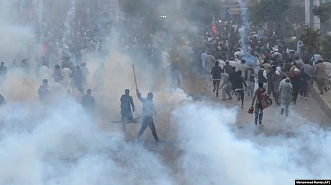 PTI supporters run for cover after police fire a tear gas shell during a protest to condemn an assassination attempt on their leader, former Prime Minister Imran Khan, in Rawalpindi on November 4.