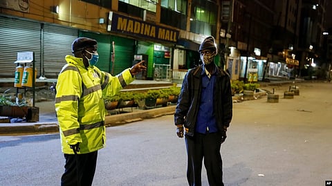 FILE - A Kenyan police officer stops a man who was heading home past the start of the daily dusk-to-dawn curfew in the Eastleigh area of Nairobi, Kenya. (AP)