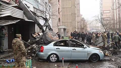 Military and onlookers stand at the site where a helicopter crashed near a kindergarten outside the capital Kyiv, killing eighteen people, including three children and the Ukrainian interior minister, on Jan. 18, 2023, amid the Russian invasion of Ukraine. (AFP)