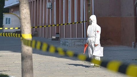 A worker in protective gear stands watch during a previous COVID-19 lockdown in Pyongyang, North Korea, May 17, 2022. Credit: AFP/KCNA via KNS