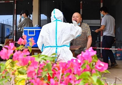 Workers line up for nucleic acid testing at the construction site of a residential area in Jiangdong New Area of Haikou, south China. (IANS)