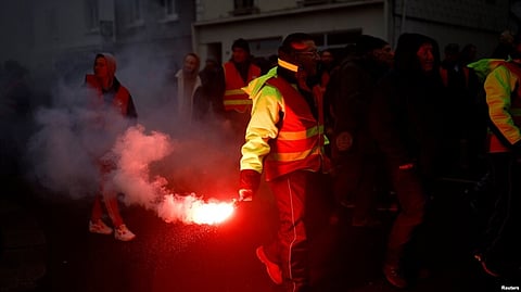 Protesters hold flares during a demonstration against the French government's pension reform plan in Saint-Nazaire as part of a day of national strike and protests in France, Jan. 19, 2023. (Reuters)