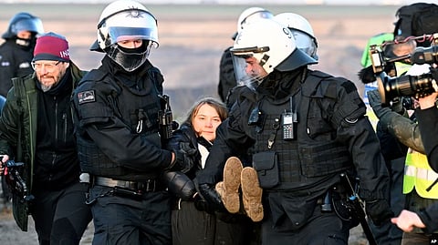 Police officers carry Swedish climate activist Greta Thunberg away from the edge of the Garzweiler II opencast lignite mine during a protest by climate activists after the clearance of Luetzerath, Germany, Jan. 17, 2023. (AP)