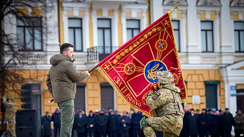 Ukrainian President Volodymyr Zelenskyy holds the flag of a military unit as an officer kisses it during a commemorative event on the occasion of the Russia Ukraine war one-year anniversary in Kyiv, Ukraine, Feb. 24, 2023. (AP)