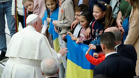 Pope Francis greets children holding up a Ukrainian flag during the weekly general audience at the Vatican, Feb. 22, 2023. (Reuters)