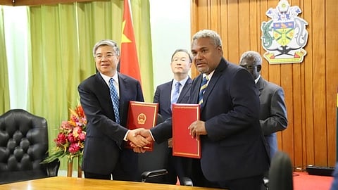 Albert Kabui (front right), special secretary to the Solomon Islands prime minister, and Tang Wenghong, vice chair of the China International Development Cooperation Agency, hold copies of an agreement as China’s ambassador to the Solomon Islands, Li Ming (rear left), and Prime Minister Manasseh Sogavare observe in the Cabinet room in Honiara, Solomon Islands.