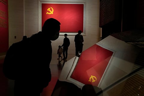 In this Oct. 12, 2022 photo, visitors walk past Communist party flags at the Museum of the Community Party of China in Beijing. (AP)