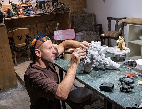 Mihaly Kolodko in his Budapest studio on July 11. The sculptor is working on a mini-statue of Vladimir Putin making snow angels atop a nuclear mushroom cloud. (RFE)
