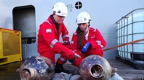 This photo released by Israel's Antiques Authority on June 20, 2024, shows Jacob Sharvit, left, and Dr. Karnit Bahartan with ancient jars that were carried on the world's oldest known deep-sea ship. VOA