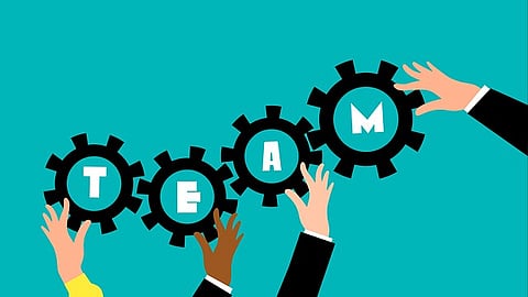 Illustration of hands holding gear wheels that spell out the word “TEAM.”