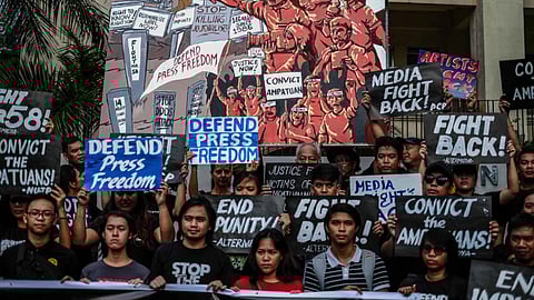 Group of people holding signs and banners protesting for press freedom