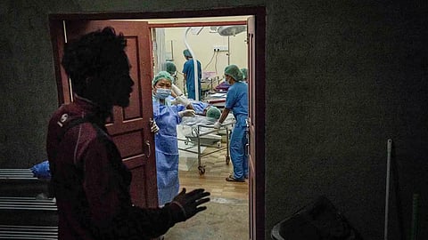 “Doctors and nurses performing surgery in an operating room.”
