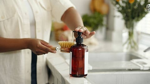 A person holds a clear bottle of liquid, showcasing its contents in a well-lit environment.