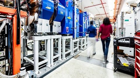 People walking inside an industrial or laboratory workspace.