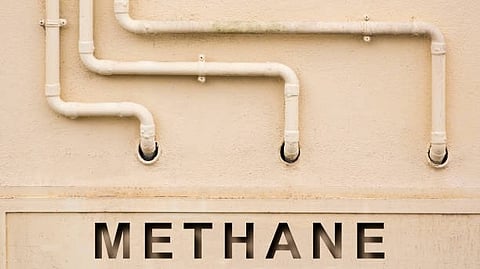 Wall with white pipes and the word "METHANE" written vertically.