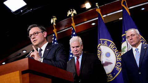 Three men standing at a podium with U.S. House of Representatives flags in the background.