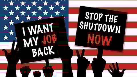 Protest signs reading “I want my job back” and “Stop the shutdown now” in front of the U.S. flag.
