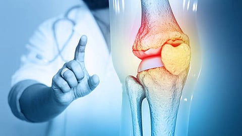 A person pointing forward, with a medical illustration below showing an inflamed elbow joint highlighted in red and yellow.